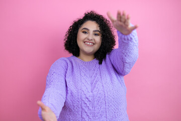 Young beautiful woman wearing casual sweater over isolated pink background looking at the camera smiling with open arms for hug
