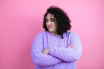 Young beautiful woman wearing casual sweater over isolated pink background thinking looking tired and bored with crossed arms