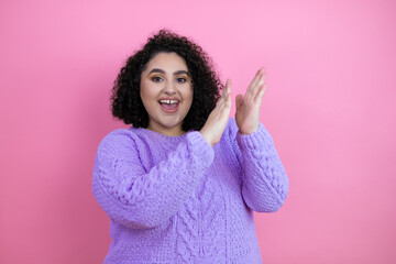 Young beautiful woman wearing casual sweater over isolated pink background clapping and applauding happy and joyful, smiling proud hands together - obrazy, fototapety, plakaty