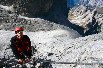 Alpinist climbing ferrata Merlone in the Dolomites, Italy, Europe