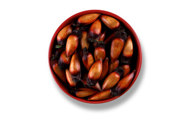 Typical araucaria seeds used as a condiment in Brazilian cuisine in winter. Brazilian pinion nuts in brown and red wooden bowl on White background