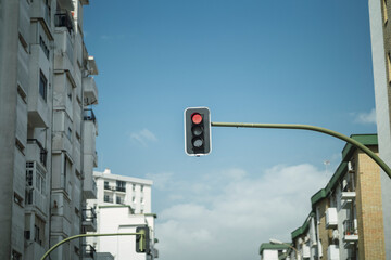 Semáforo en mitad de la calle con el cielo azul de fondo