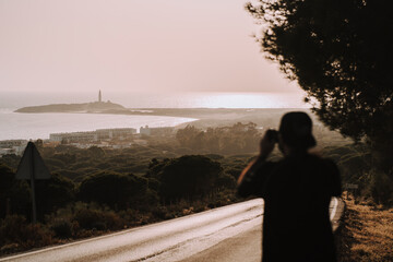 Chico tomando fotos al faro de trafalgar de cadiz