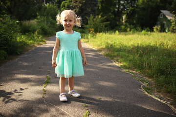 Fototapeta premium Portrait of a happy liitle blond girl close-up. 3 yaers caucasian todler girl smiling at outdoors walk.