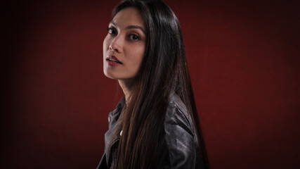 Fototapeta premium Young pretty woman in black leather jacket posing for the camera - studio photography
