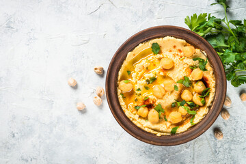 Hummus with olive oil and paprika at light kitchen table.