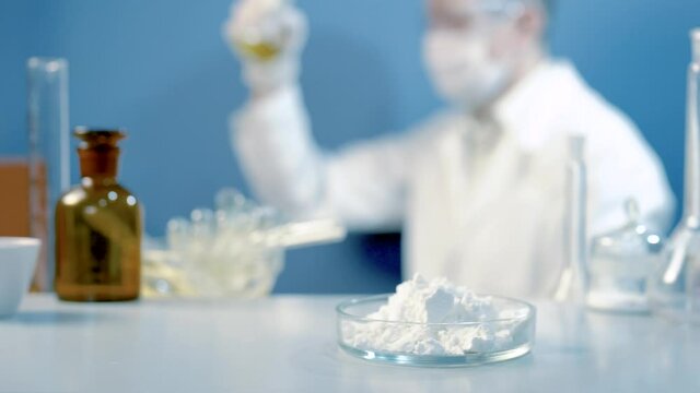 Chemical laboratory food supply. GMO Genetically modified products in the laboratory. A lab technician in a white coat holds nitric acid in his hand.