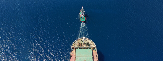 Aerial drone ultra wide photo of huge crude oil tanker ship guided by tug boats