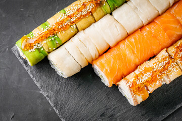 appetizing set of sushi roll on a black stone plate