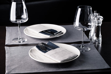 Elegant table setting white plates on black wooden table