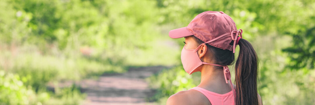 Mask covid-19 outside lifestyle woman walking at outdoor park wearing pink face cover for coronavirus prevention.