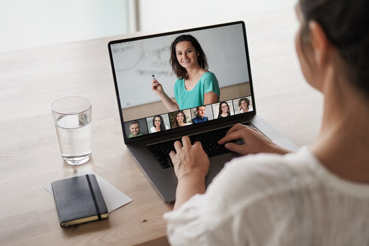 remote online working woman sitting on a work desk with laptop in in her home office joining an online meeting or watching video conference or webinar presentation