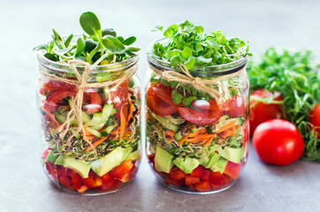 Vegetables salad in open jar Tomato, avocado,pepper, cucumber, micro greens Healthy food, diet,...