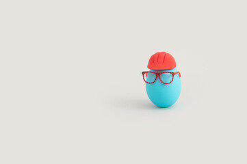 Funny Easter concept  with blue color egg with eyeglasses and safety helmet