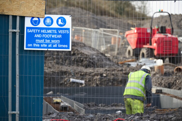 Construction site health and safety message rules sign board signage on fence boundary