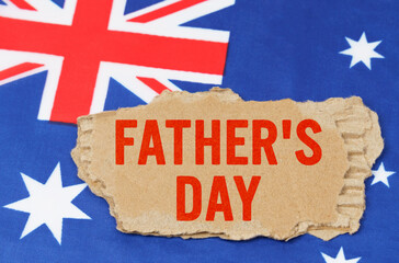 Fototapeta na wymiar Against the background of the flag of Australia lies cardboard with the inscription - Fathers Day