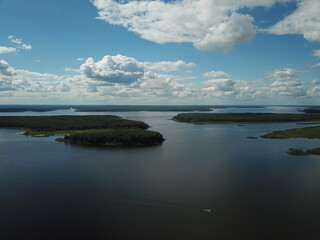 Beautiful river landscape top view from drone. Green small islands against a background of blue sky and white clouds