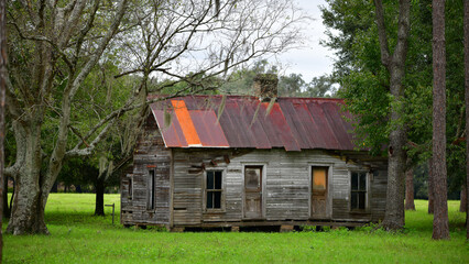 Plakat old abandoned farm house with rusty tin roof in North Florida