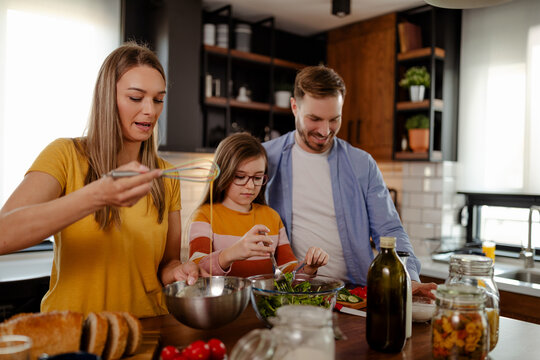 The family is preparing lunch. Dad, mom, and daughter time. Spend quality family time together.