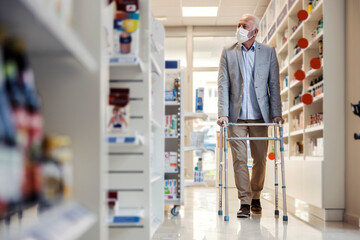 Man with walkers for the elderly goes around the shelves with medicines in the pharmacy. An old man...