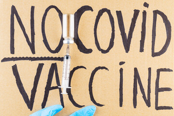 'No covid vaccine' protestive placard. Anti-vaccination poster, vaccine bottle and syringe. Concept covid-19 coronavirus vaccination protest