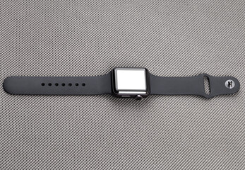 Smart watch with a blank white screen on a gray background.