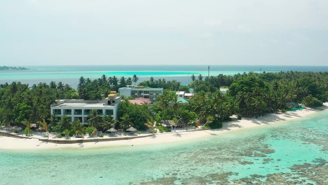 Drone view of a tropical island with a hotel and residential property. Thinadhoo (Vaavu Atoll), Maldives