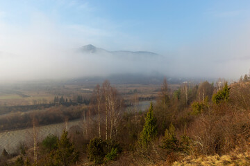 Sunrise over the mountains shrouded in fog. Landscape of the mountain river Stryi, Carpathian mountains, Ukraine, Europe. Carpathian mountains, Beskydy region view of the valley of the river Stryi.