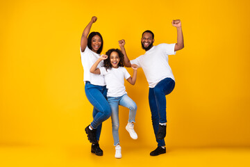 Portrait of emotional black family dancing at studio