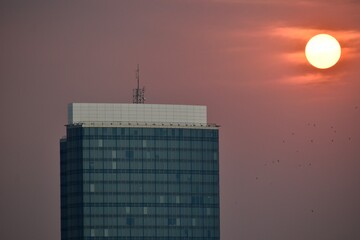 Obraz premium Top floors of a skyscraper and sunset in the background 