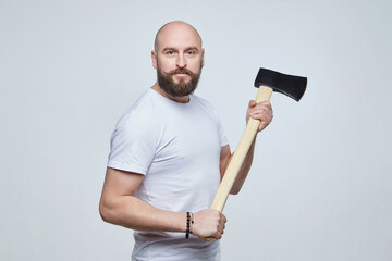 man of Caucasian appearance makes a swing with an axe. photo shoot in the studio