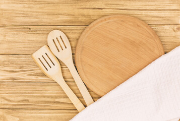 Empty pizza board, wooden cutlery and napkin on wooden table. Empty tray. Mockup.