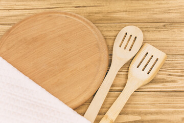 Empty pizza board, wooden cutlery and napkin on wooden table. Empty tray. Mockup.