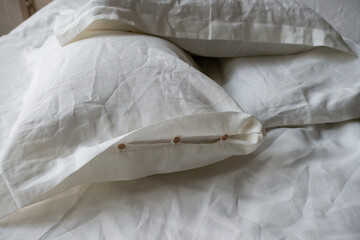Trendy organic natural linen bedclothes with wooden buttons closeup