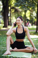 Fitness girl with a smartphone on nature background.
