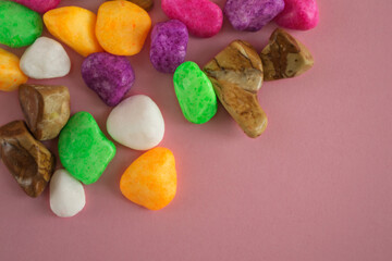 Colored stones, on a pink background, top view, lying on a flat surface