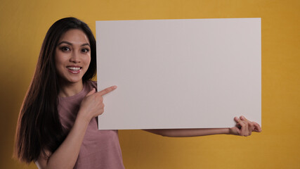 Young beautiful woman holds a sign - studio photography