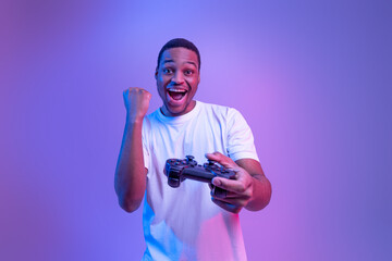 Video Gaming Concept. Euphoric African American Guy With Joystick Celebrating Game Win