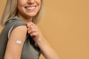 Happy vaccinated woman showing arm after vaccine injection, studio background, closeup - obrazy, fototapety, plakaty