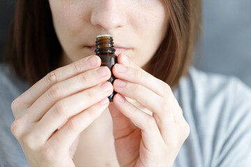 young and beautiful Caucasian women sniff a tube of aromatic oil, to check for covid-19 symptoms or...