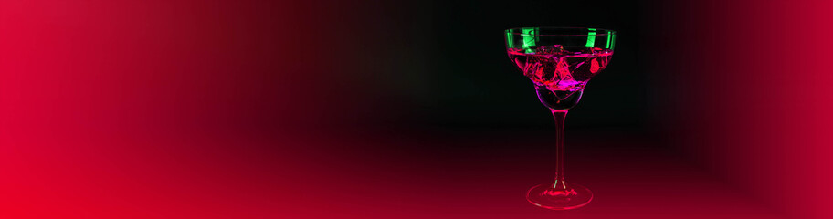 Red drink in a cocktail margarita glass with ice cubes on the hypnotic background