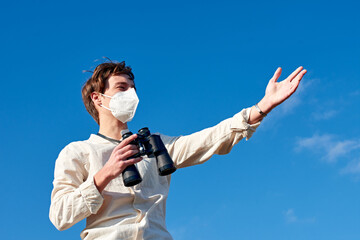 A portrait of a satisfied young man from Spain wearing a mask staring into the distance showing...