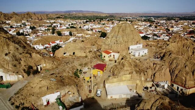 View from drone of famous cave house area in municipality of Guadix on background with medieval Moorish fortress alcazaba, Granada, Spain