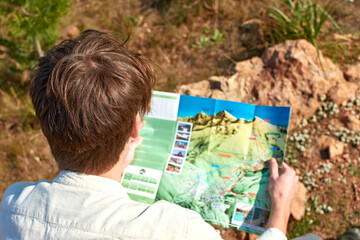 A closeup of a young explorer from Spain In search of mountains observing a map