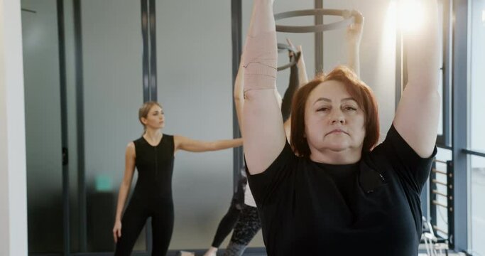 Energetics ring for sports and pilates in the hands of an older woman and a young girl at an active training session in a dispute