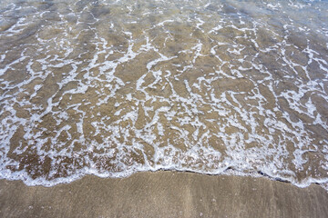 Sand and waves on the beach with empty space for text. 
