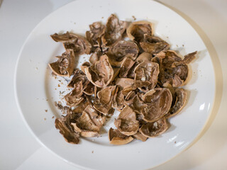 Walnut shells on a white plate. White background