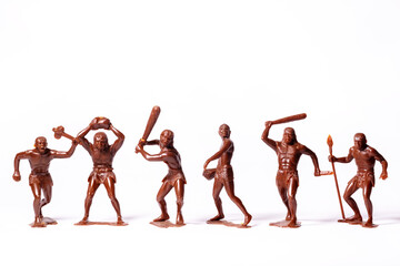Fototapeta na wymiar Large toy figures of primitive people on a white background