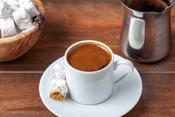Traditional Turkish coffee served in classical cups with Turkish delights. A metal coffee pot is in...