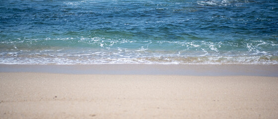 Ocean shore. Blue sea and golden sand. Wide shot.